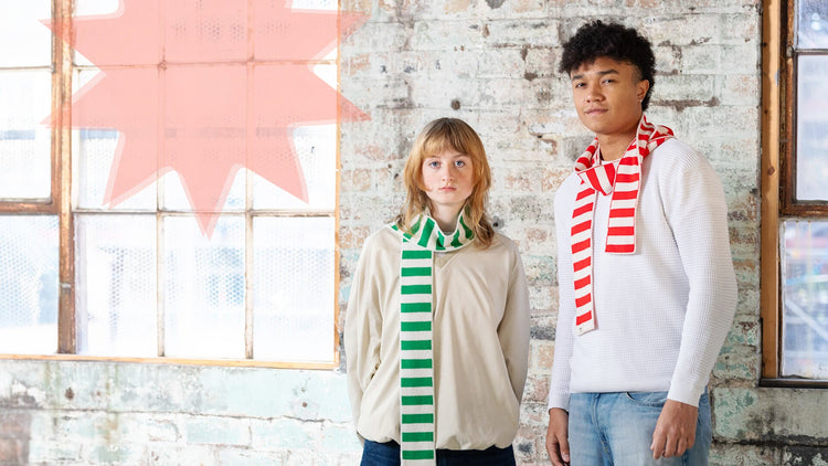 white woman wearing a green and cream striped merino wool skinny scarf
