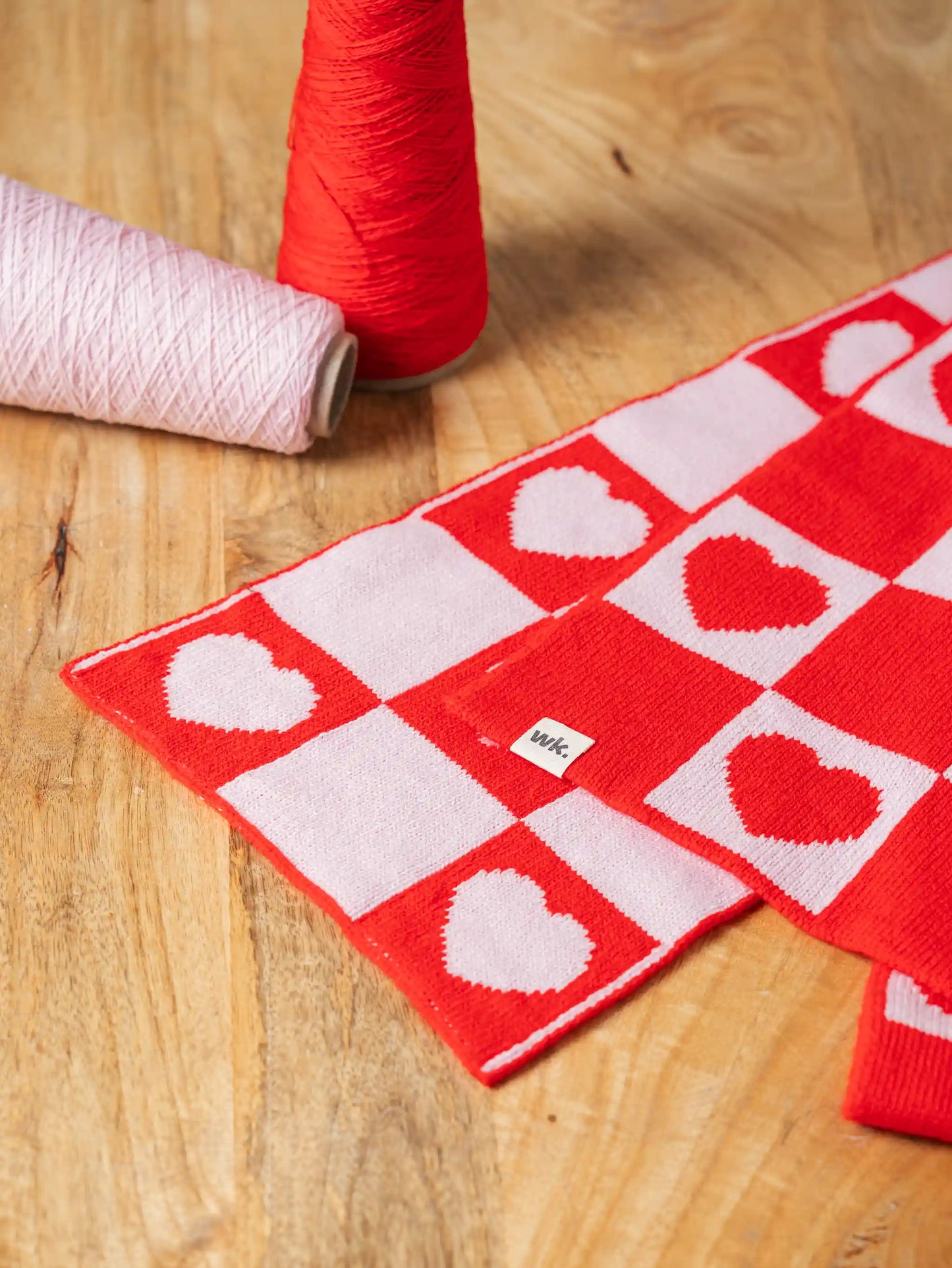 merino wool love heart scarf in red and white flat lay with yarn - Woolkind