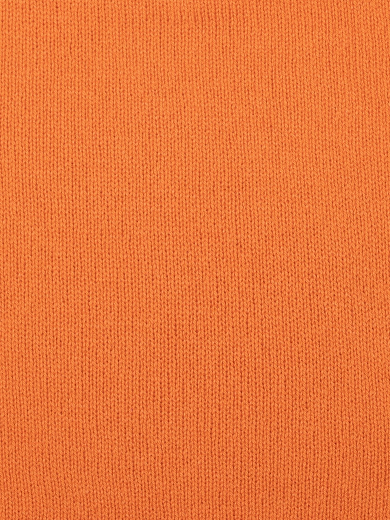 a swatch of plain single jersey knitting made from fine merino wool in an orange colour