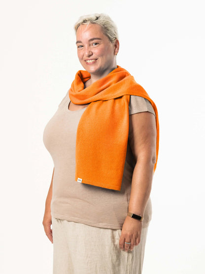 White woman wearing a lightweight quality orange merino wool scarf - woolkind