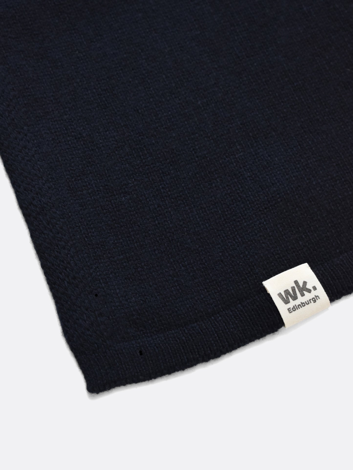 a swatch of plain single jersey knitting made from fine merino wool in a dark navy colour