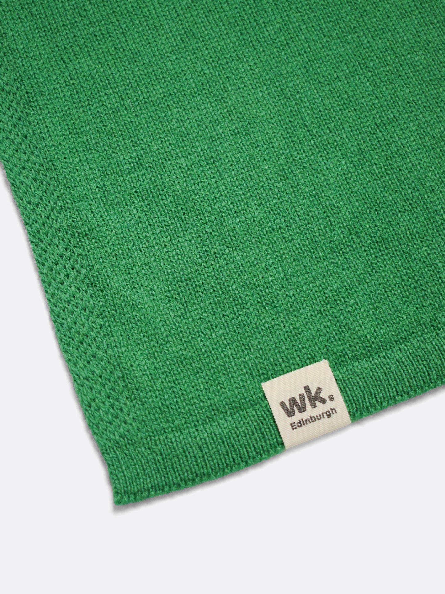 a swatch of plain single jersey knitting made from fine merino wool in a green colour