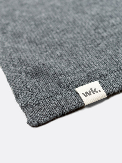 a swatch of plain single jersey knitting made from fine merino wool in a dark grey colour