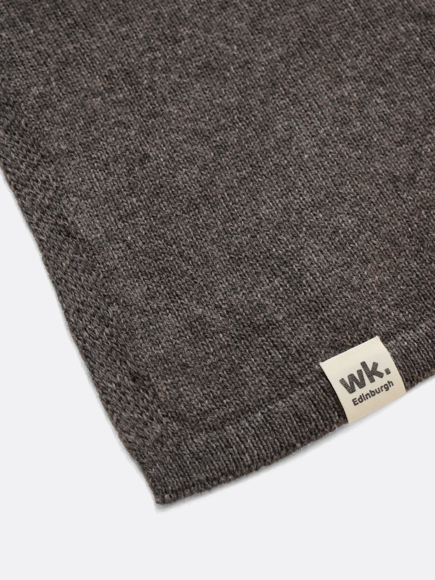 a swatch of plain single jersey knitting made from fine merino wool in a dark brown colour