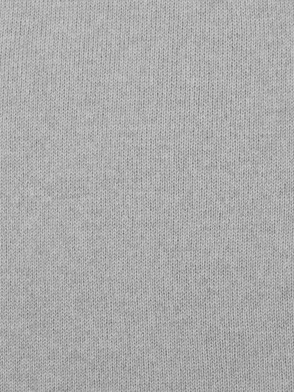 a swatch of plain single jersey knitting made from fine merino wool in a light grey colour
