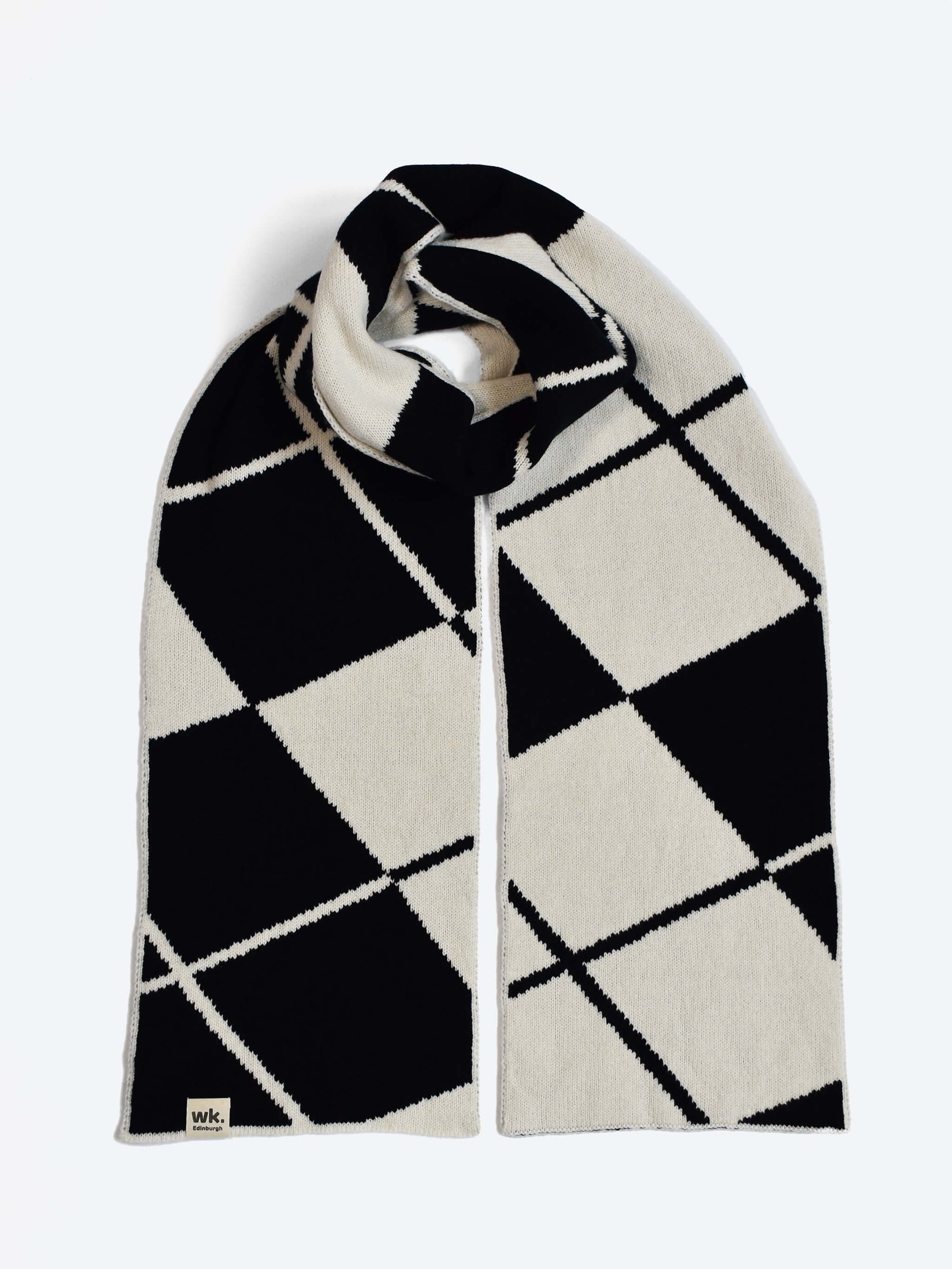 Navy and white argyle merino wool scarf on a light gray background