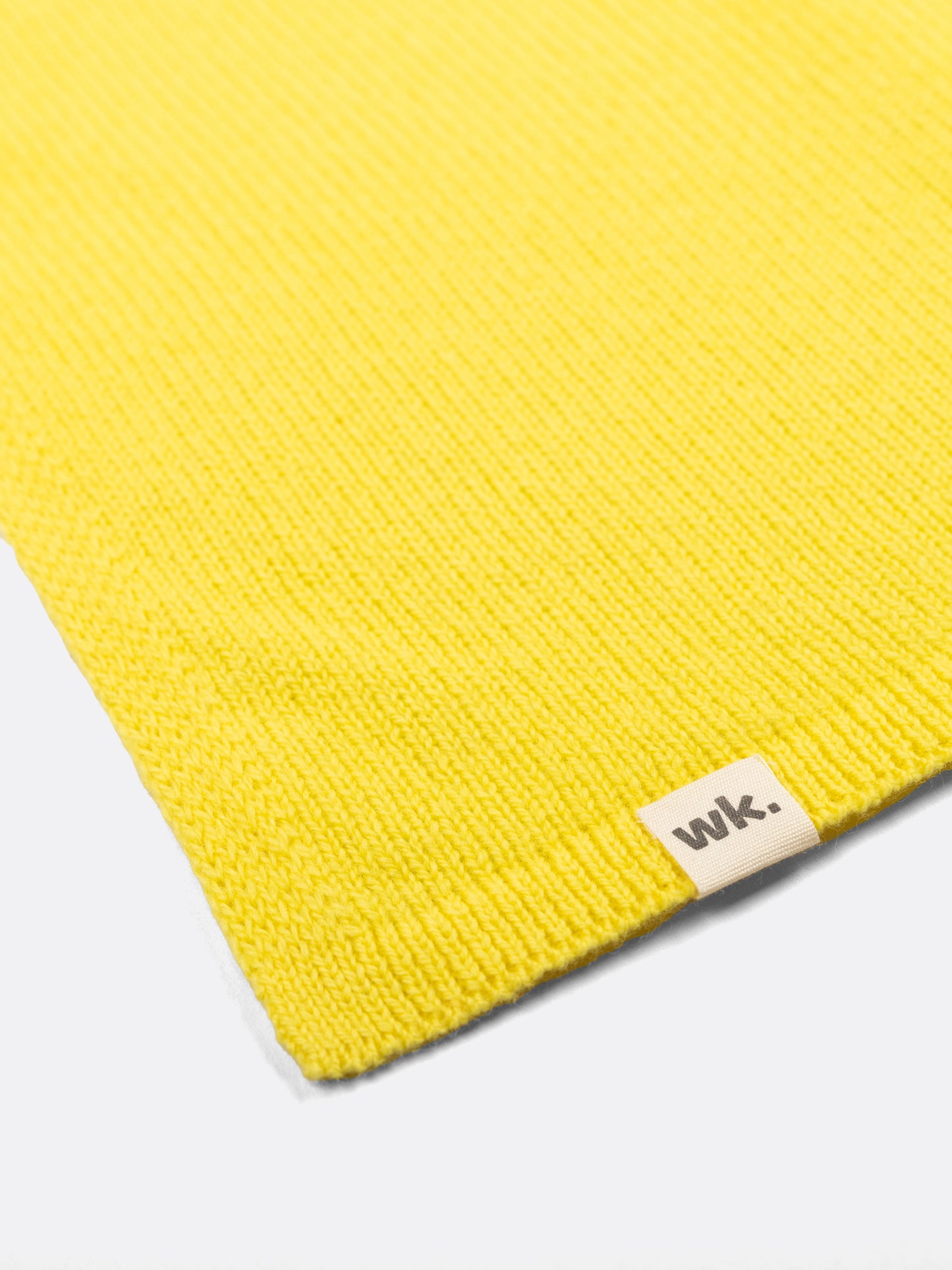 a swatch of plain single jersey knitting made from fine merino wool in a yellow colour