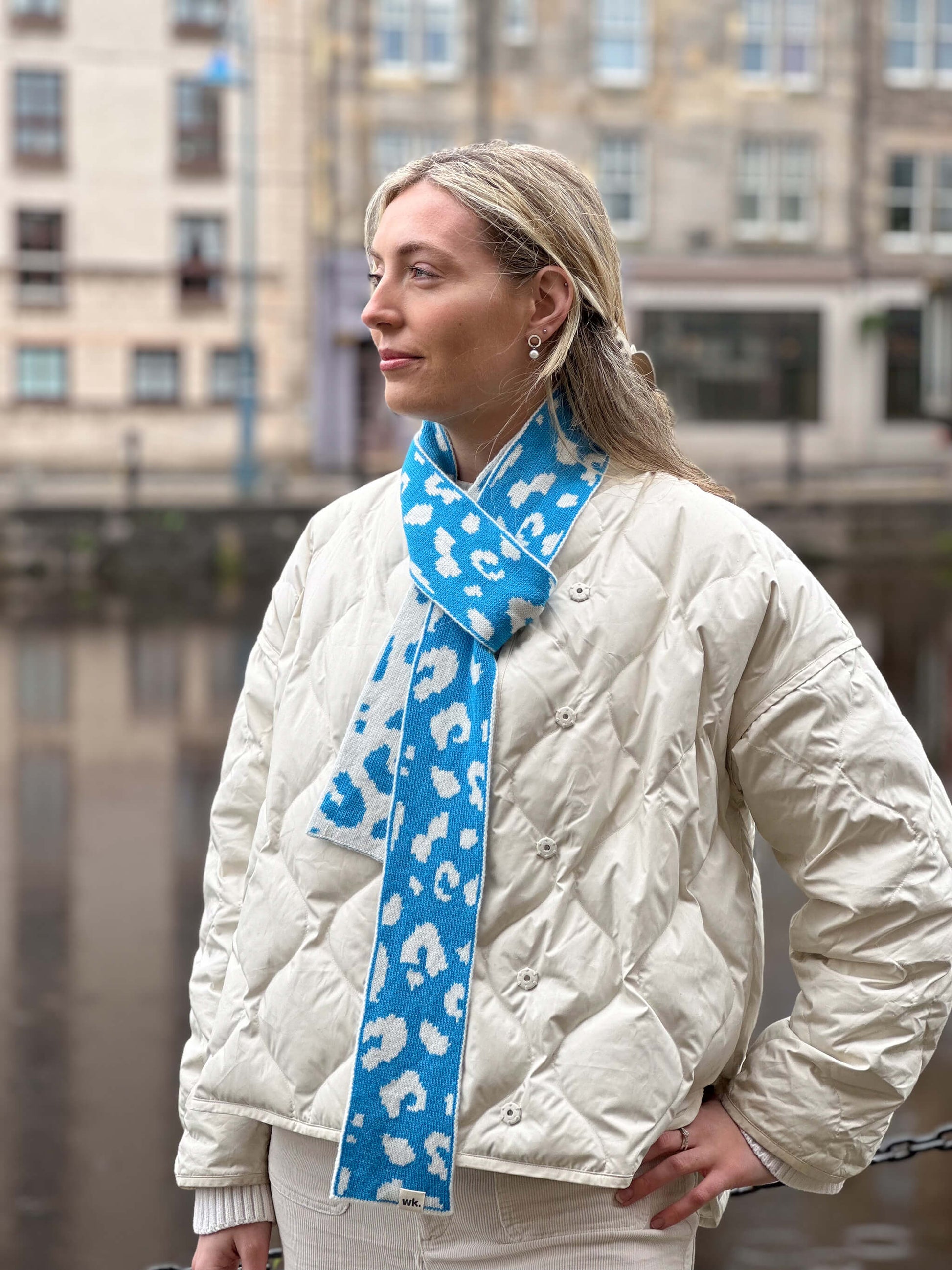 white woman wearing a blue and cream skinny merino wool leopard print scarf - Woolkind