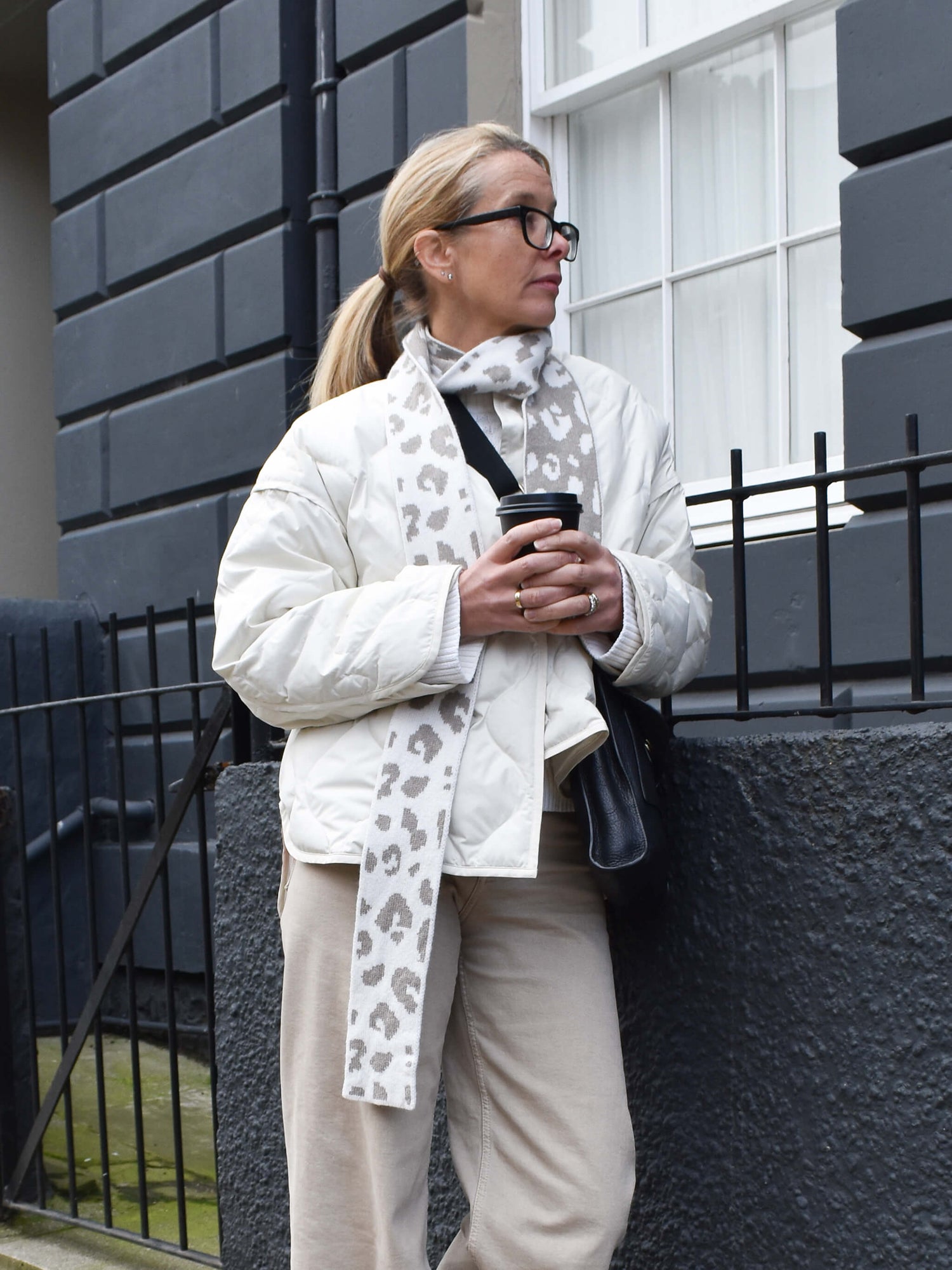 white woman wearing a light brown and cream skinny merino wool leopard print scarf - Woolkind