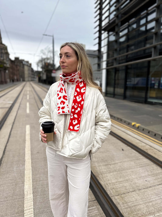 white woman wearing a red and cream skinny merino wool leopard print scarf - Woolkind